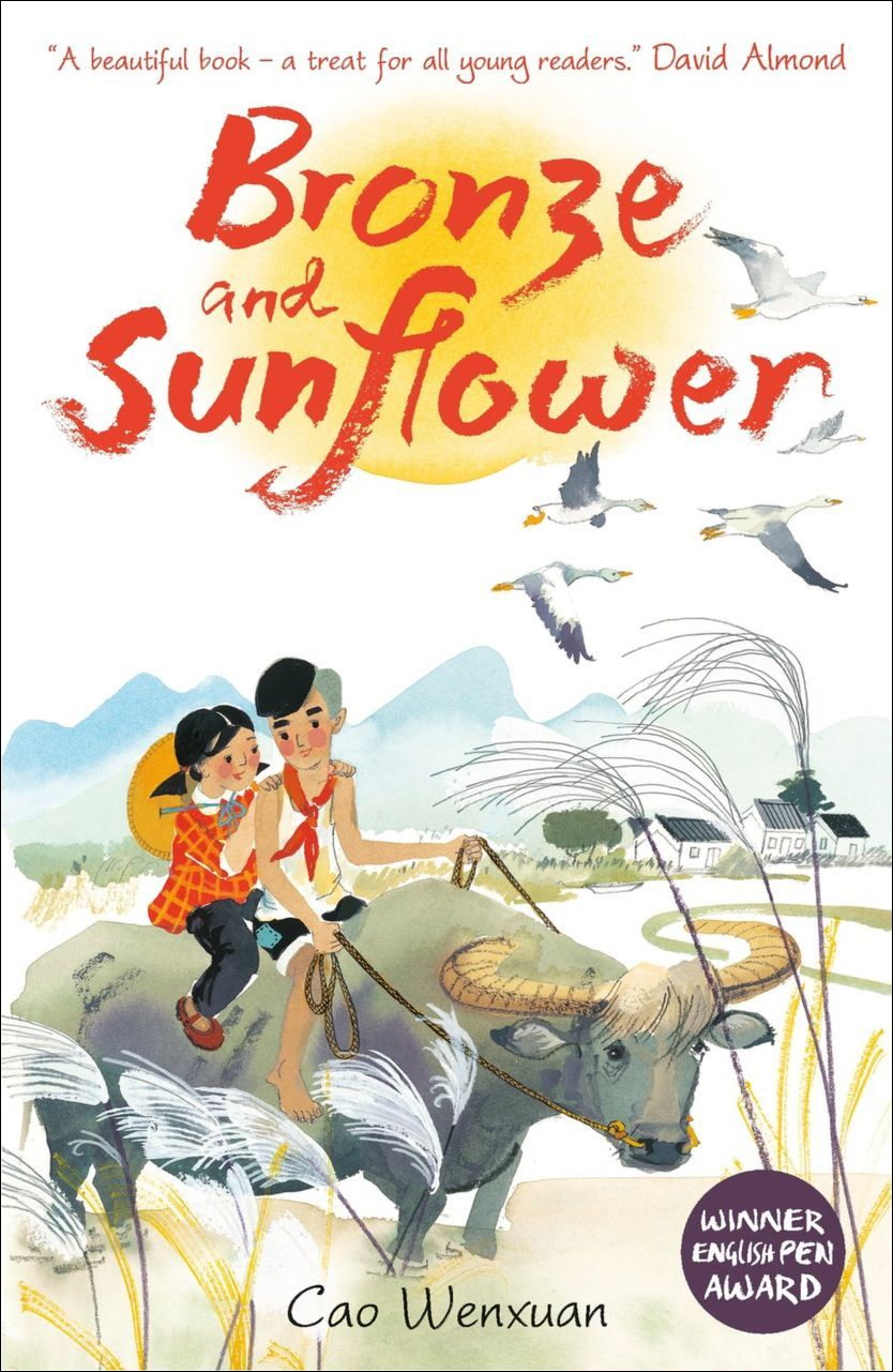 Cover of Bronze and Sunflower featuring an illustration of two kids, a boy and a girl, riding on the back of a water buffalo who is wading through a rice paddy. In the background is a rural landscape, houses, mountains, and birds.