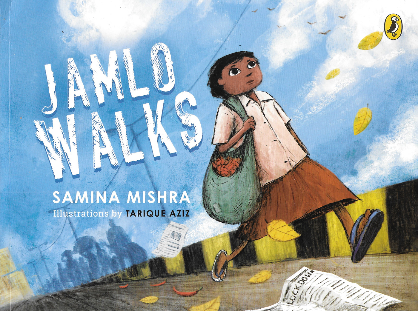 Cover of Jamlo Walks featuring an illustration of a young boy walking in a city landscape with a bag over his shoulder and a newspaper on the ground in the foreground. There is a cloudy vivid blue sky in the background and the title is displayed in a stylizes rugged white font.