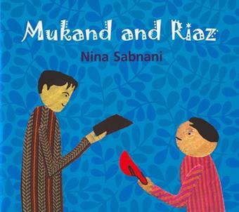 Cover of Mukand and Riaz featuring a collage-like illustration of two boys, one taller and one shorter, with the taller one on the left handing a black object to the boy on the right who is holding a red hat in his hand. The cover's background is blue and textured with a pattern of blue foliage and the title is displayed in a decorative white font.