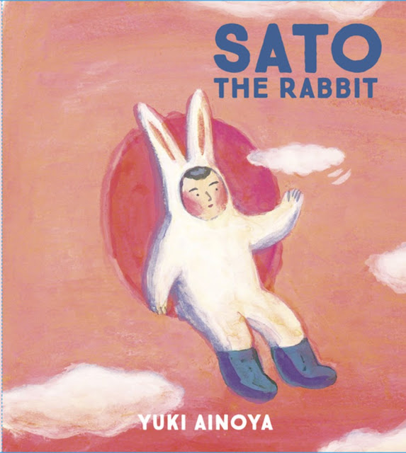 Cover of Sato the Rabbit featuring a child in a rabbit costume surrounded by clouds and a pinkish-orange hue and playing with a small cloud.